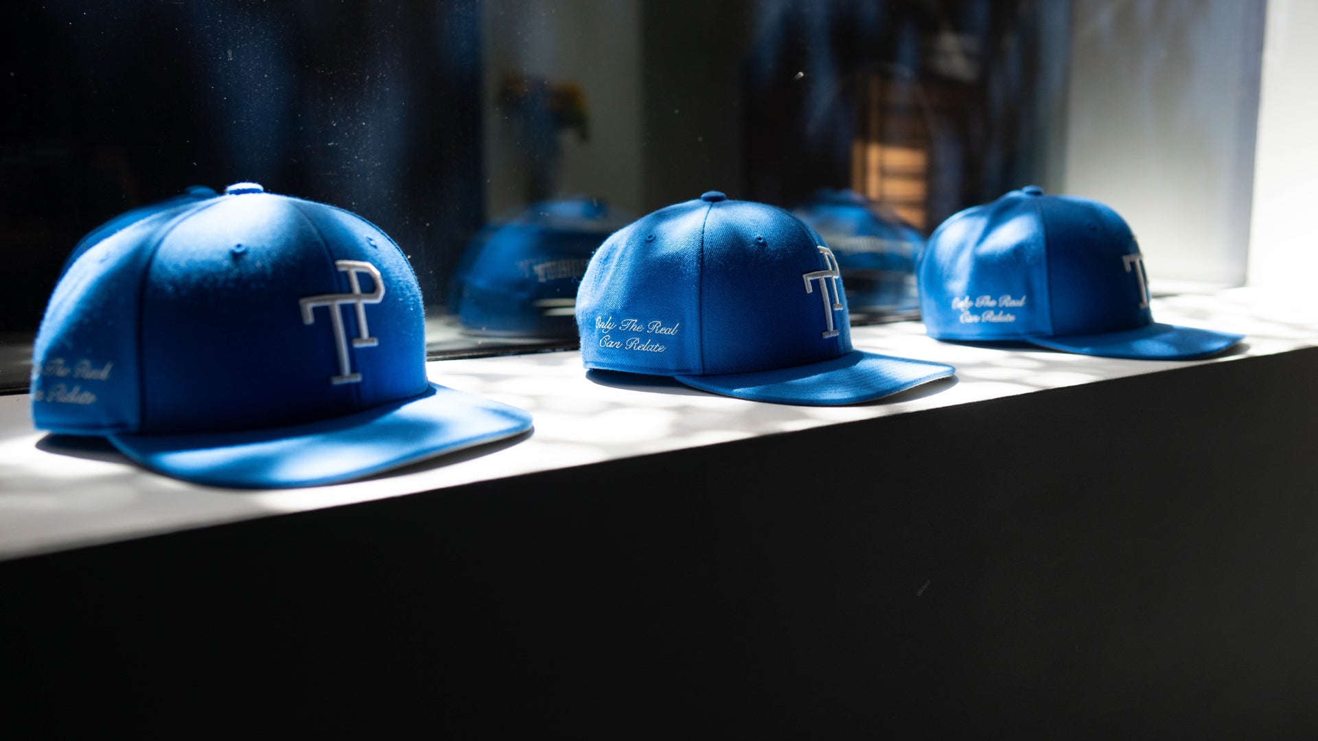 Dark green TP baseball cap with white embroidered logo resting on matte green Mercedes-Benz G-Wagon hood.