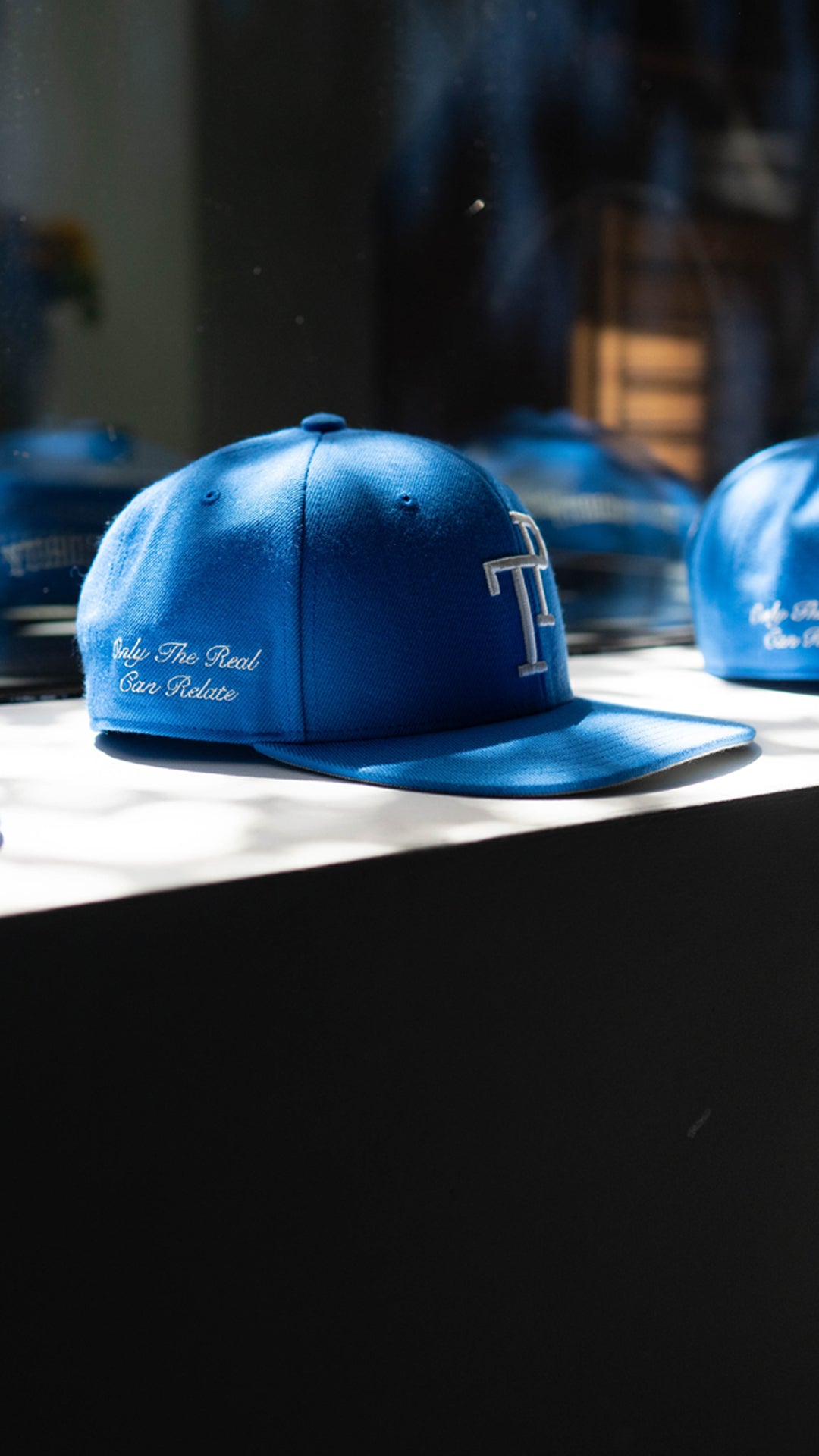 Dark green TP baseball cap with white embroidered logo resting on matte green Mercedes-Benz G-Wagon hood.