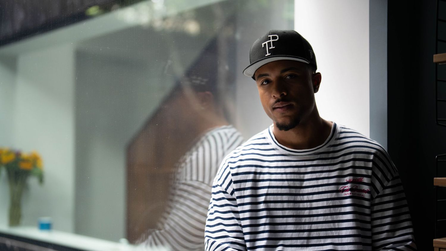 Dark green TP baseball cap with white embroidered logo resting on matte green Mercedes-Benz G-Wagon hood.