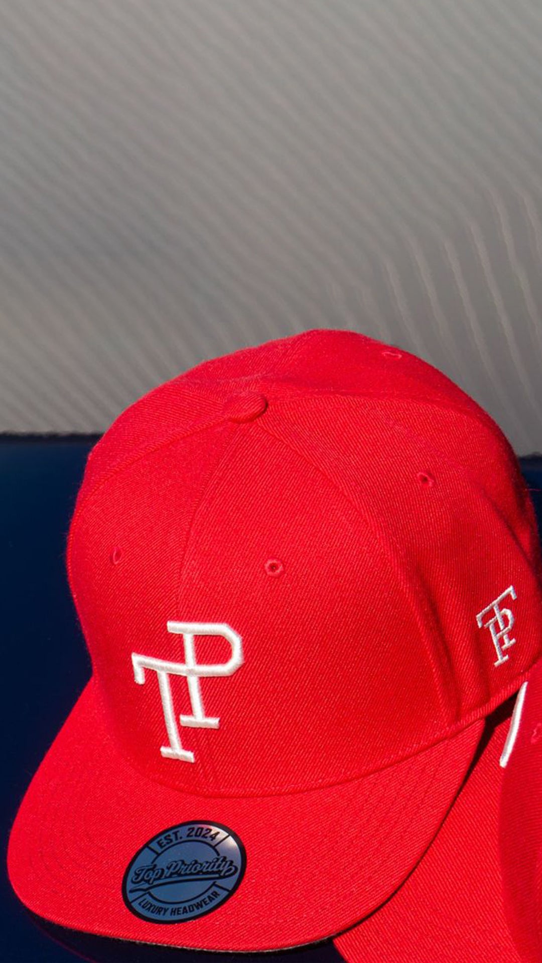 Dark green TP baseball cap with white embroidered logo resting on matte green Mercedes-Benz G-Wagon hood.