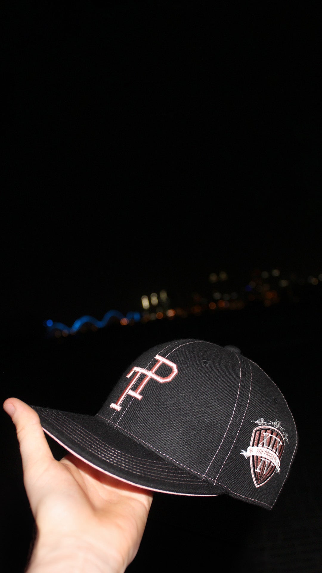 Dark green TP baseball cap with white embroidered logo resting on matte green Mercedes-Benz G-Wagon hood.