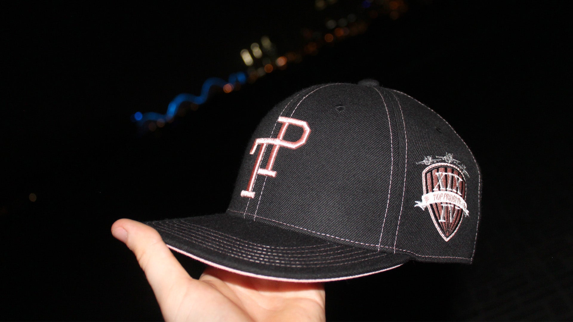 Dark green TP baseball cap with white embroidered logo resting on matte green Mercedes-Benz G-Wagon hood.